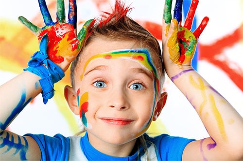nino-sonriendo-manos-llenas-de-pintura